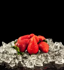 Poster aardbei op zwarte achtergrond. aardbeien met ijsblokjes erop © EwaStudio
