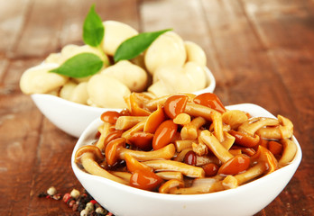 Mushrooms in bowls, on wooden background