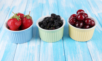 Ripe mulberries with cherry and strawberries in bowls