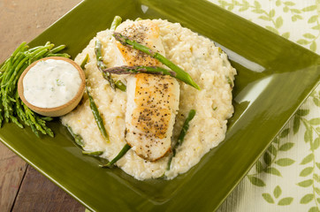 Halibut with asparagus risotto on green plate