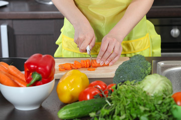 Woman in the kitchen cut vegetables