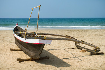 Old fishing boat on the sandy shore in Goa, India