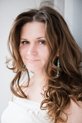 Obraz premium Portrait of beautiful young happy smiling woman with long curly