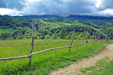 Fototapeta na wymiar Górska droga między ogrodzeniem