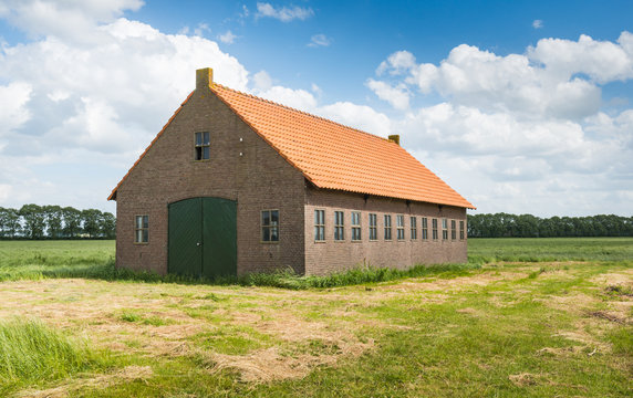 Old Dutch barn of brick masonry with an orange tile roof