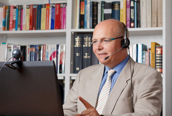 Lehrer mit Headset und Webcam