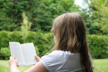 Mädchen liest im Garten ein Buch
