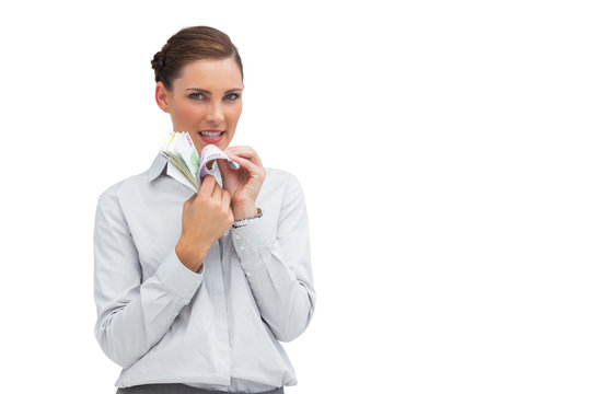 Businesswoman counting money and looking at camera