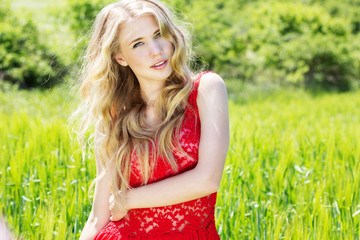 Naklejka na ściany i meble beautiful blonde girl in green field