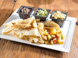 tray of toasted artisan bread, salsa and fresh dips
