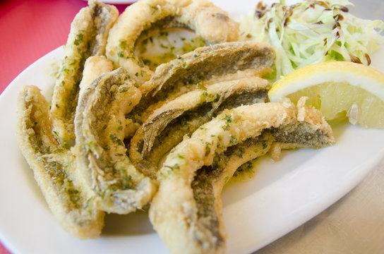 Spider fish fillets coated with salad and lemon.(Trachinus)