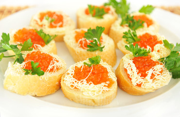 Plate with sandwiches with red caviar.
