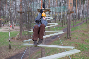Little climber goes zigzag obstacle holding safety rope