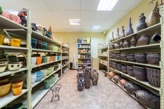 Room with shelves full of ceramic flowerpot and pitcher