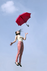 Frau springt mit Regenschirm