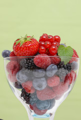 Beeren im Glas vor grünem Hintergrund