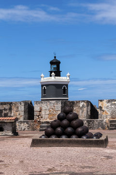 cannonballs at  El Morro fort in San Juan, lighthouse in backgro