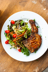 Pork chop with salad on table top view