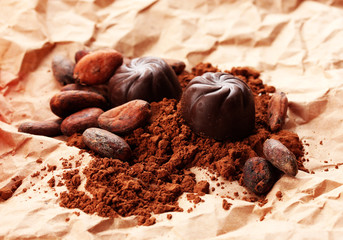 Composition of chocolate sweets and cocoa on brown background