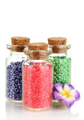 Little bottles full with colorful beads isolated on white