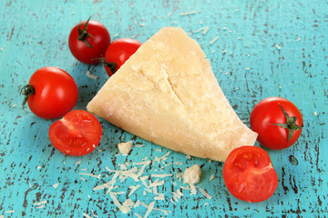 Piece of Parmesan cheese on wooden blue table close-up