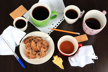 Cups of coffee and cookies on plate on dark background