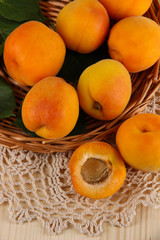 Apricots on wicker coasters on napkin on  wooden table