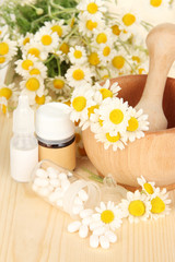 Medicine chamomile flowers on wooden table