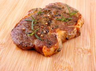 Grilled steak meat with herb marinade on bamboo board