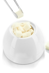 Refined sugar in white sugar bowl on grey background