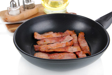 Fried bacon in frying pan  isolated on white