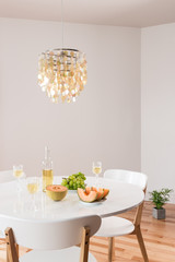 Decorative chandelier and elegant table with white wine