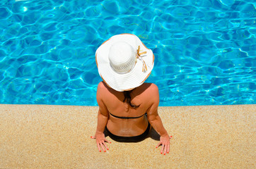 Fototapeta na wymiar Young woman relaxing by the pool