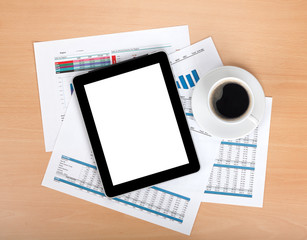 Tablet with blank screen over papers with numbers and charts