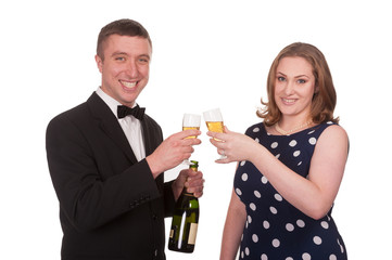 Happy couple celebrating with champagne - isolated on white