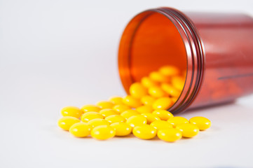 Yellow tablet and brown prescription bottle