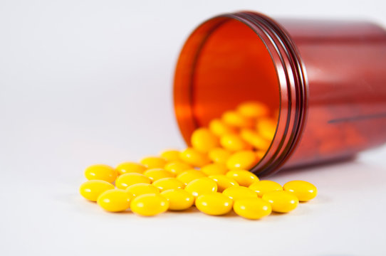 Yellow tablet and brown prescription bottle
