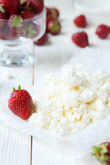 Fresh cottage cheese and strawberries on the table