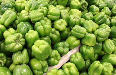 Fototapeta na wymiar Bins of fresh sweet green peppers at the market