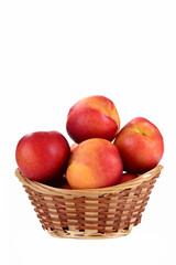 Fresh fruit nectarines in the basket, on white background