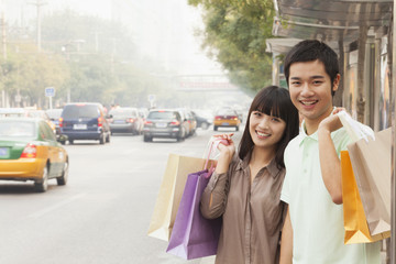 Portrait of smiling young couple at the bus stop, Beijing, China