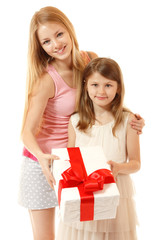 happy little girl holding christmas present with her sisiter
