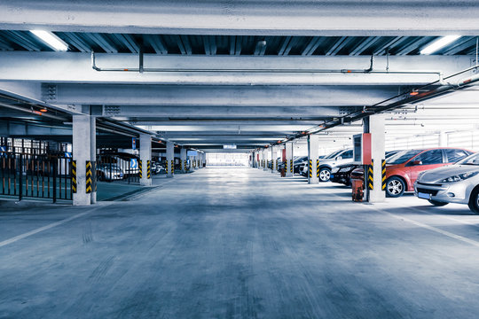 Parking garage, interior with a few parked cars.