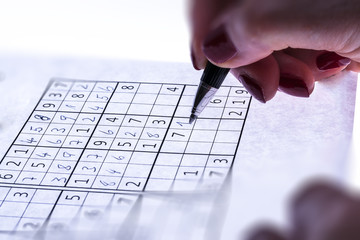 Close-up a pencil in Hand and puzzle sudoku