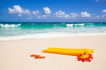 flip-flops and air mattress at the beach