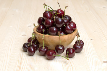 Bowl of ripe cherries on a wooden table