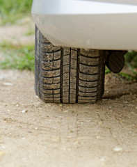 Car wheels on a dusty road detail