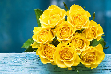 Yellow roses bouquet on the blue background