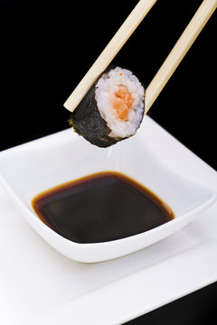 holding sushi with chopsticks