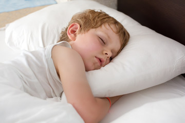 Fototapeta na wymiar Little sweet toddler boy sleeping in his bed